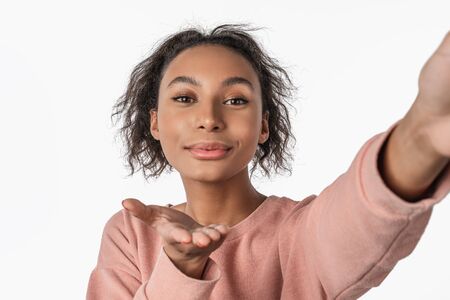 Close up of young african american girl in sweater posing isolated on white wall backgroundの写真素材
