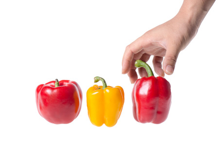 colored peppers and a hand over white backgroundの写真素材
