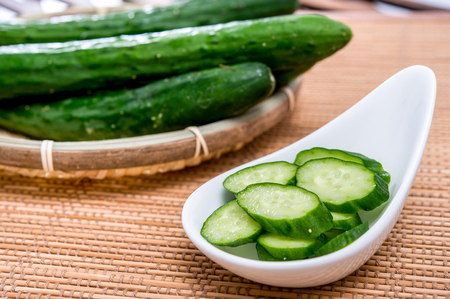 sliced green cucumber in white plateの写真素材