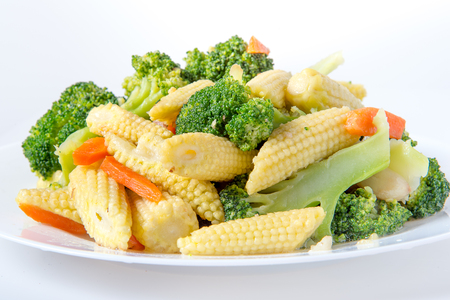 Green broccoli, baby corn, carrot on the plateの写真素材