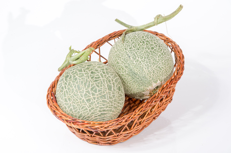 Cantaloupe (Muskmelon) in basket isolated on white backgroundの写真素材