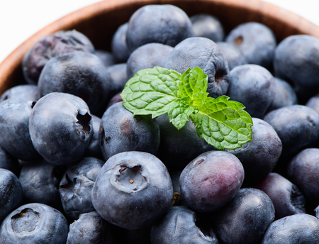 Close up blueberry with vanilla mint in a wooden bowl isolated on white backgroundの写真素材
