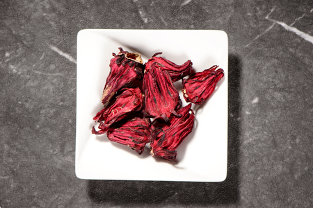 Chinese herbal medicines - Roselle in white plate on stone backgroundの写真素材