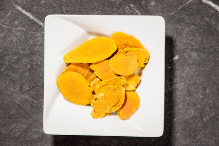 Chinese herbal medicines - Closeup turmeric roots slices on stone backgroundの写真素材