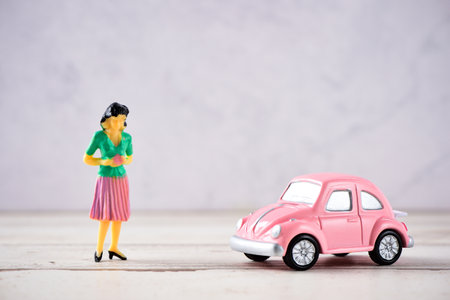 Taiwan, Tainan - April 17, 2018: Miniature people: A mother who is given a heart in love by little child girl with little bettle pink car, the concept of Mother's Day, blank background for text, macro shotのeditorial素材