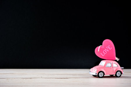 Taiwan, Tainan - April 17, 2018: Little beetle pink car carries a heart with love in blank background for text, Valentine's Day concept, Mother's Day concept, macro shot.のeditorial素材