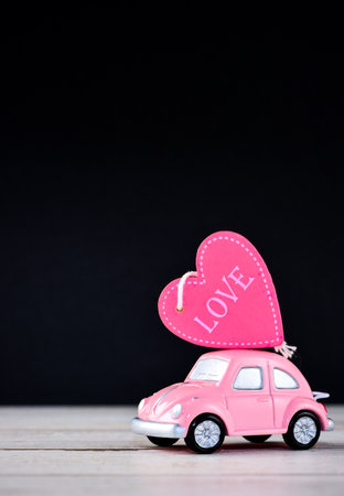 Taiwan, Tainan - April 17, 2018: Little beetle pink car carries a heart with love in blank background for text, Valentine's Day concept, Mother's Day concept, macro shot.のeditorial素材