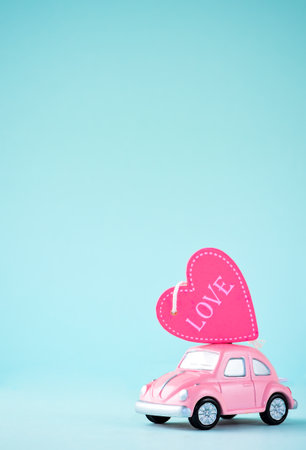 Taiwan, Tainan - April 17, 2018: Little beetle pink car carries a heart with love in blank background for text, Valentine's Day concept, Mother's Day concept, macro shot.のeditorial素材
