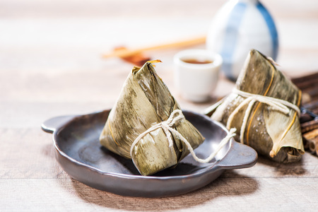 Zongzi(rice dumpling) with a cup of tea on a wood table, Dragon Boat Festival, Asian traditional food, Chineseの写真素材