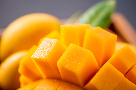 Fresh and beautiful mango fruit set in a wooden box with sliced ??diced mango chunks on a dark wooden background, copy space(text space), blank for textの写真素材