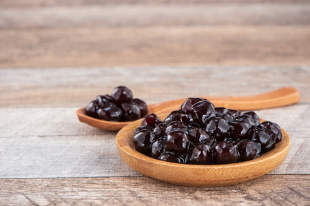 Tapioca Pearl , Bubble topping for tea or other beverage, in a cup, place on wooden table. Copy spaceの写真素材