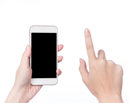 Closeup shot of a woman typing on mobile phone isolated on white background.. Girl's hand holding a modern smartphone and pointing with figer. Blank screen to put it on your own webpage or message.の写真素材