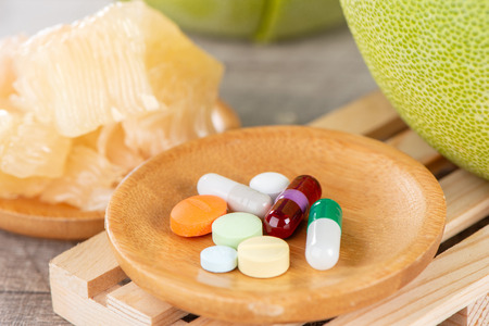 fresh and peeled pomelo(shaddock), grapefruit with drug, concept of drug interatcionsの写真素材