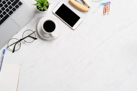 Stylized marble office working desk with smartphone, laptop, glasses and coffee, workspace design, mock up, topview, flatlay, copyspace, closeupの写真素材