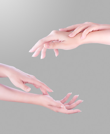 Beautiful and elegant adult woman empty hands side isolated on gradient gray background, concept of applying moisturizing cream, body care, manicure, close upの写真素材