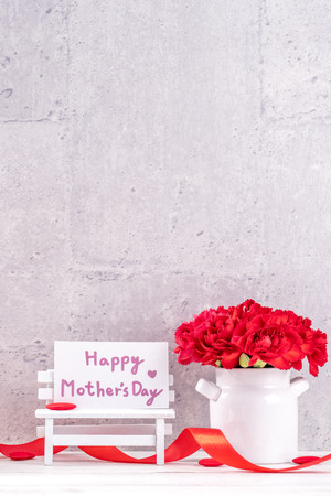 May mothers day handmade giftbox wishes photography - Beautiful blooming carnations with red ribbon box isolated on fair-faced gray background desk, close up, copy space, mock upの写真素材