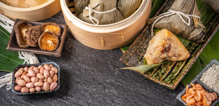 Close up, copy space, top view, famous asian chinese tasty handmade food in dragon boat(duan wu) festival, steamed rice dumplings shaped pyramidal by leaves ingredientsの写真素材