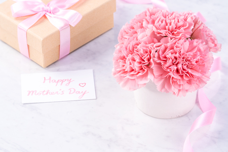Copy space, close up, mock up, clipping path. Mothers day wording concept design. Beautiful fresh blooming baby pink color carnations isolated on bright marble background.の写真素材