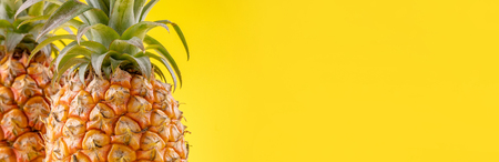 Beautiful fresh pineapple isolated on bright yellow background, summer seasonal fruit design idea...