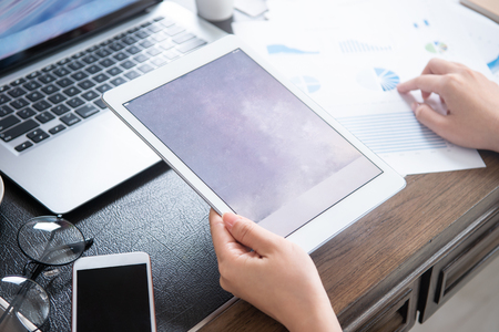Business concept. Woman using tablet for project with digital device in office desk. Backlighting, sun glare effect, close up, side view, copy spaceの写真素材