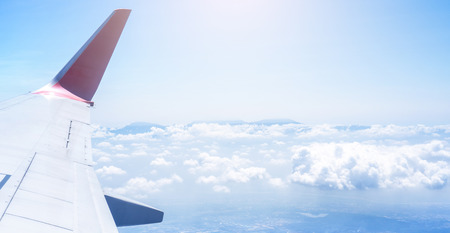 Bussiness and travel concept. Aerial view through window inside aircraft cabin with beautiful blue sky and cloud with sunlight, copy space, top viewの写真素材