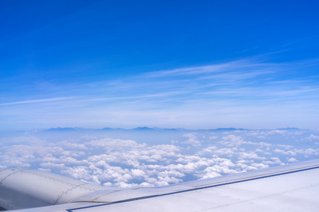 Bussiness and travel concept. Aerial view through window inside aircraft cabin with beautiful blue...
