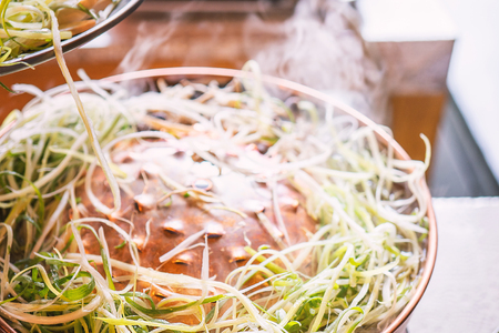 Beef barbecue bulgogi in South Korea restaurant in Seoul, lifestyle fresh korean food cuisine on copper pan with sliced grill, close up, copy spaceの写真素材