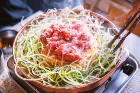 Beef barbecue bulgogi in South Korea restaurant in Seoul, lifestyle fresh korean food cuisine on copper pan with sliced grill, close up, copy spaceの写真素材