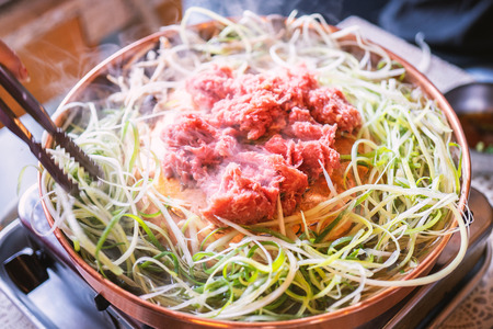 Beef barbecue bulgogi in South Korea restaurant in Seoul, lifestyle fresh korean food cuisine on copper pan with sliced grill, close up, copy spaceの写真素材