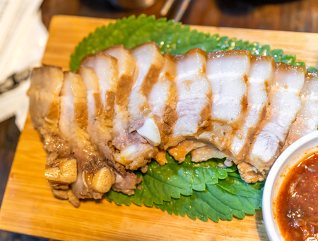 Pan-fried cooked black pork meal in Korea restaurant, fresh delicious korean food cuisine on iron plate with lettuce, close up, copy space, lifestyleの写真素材