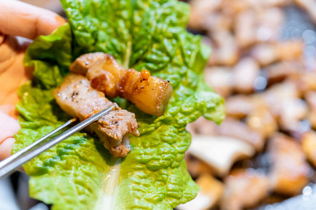 Pan-fried cooked black pork meal in Korea restaurant, fresh delicious korean food cuisine on iron plate with lettuce, close up, copy space, lifestyleの写真素材