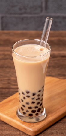Delicious bubble milk tea with straw in drinking glass on wooden table background, concept of reduce plastic to go in Taiwan, close up, copy spaceの写真素材