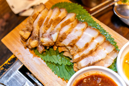 Pan-fried cooked black pork meal in Korea restaurant, fresh delicious korean food cuisine on iron plate with lettuce, close up, copy space, lifestyleの写真素材