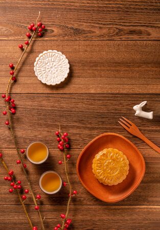 Chinese traditional mooncake with teacups on wooden background, Mid-Autumn Festival concept, top view, flat lay.