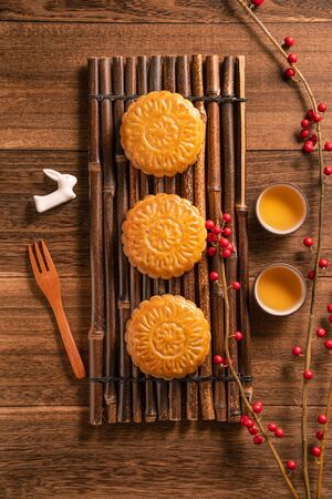 Chinese traditional mooncake with teacups on wooden background, Mid-Autumn Festival concept, top view, flat lay.の写真素材