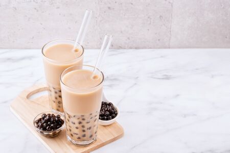 Taiwanese popular beverage - Pearl milk tea on wooden board over marble white tableの写真素材