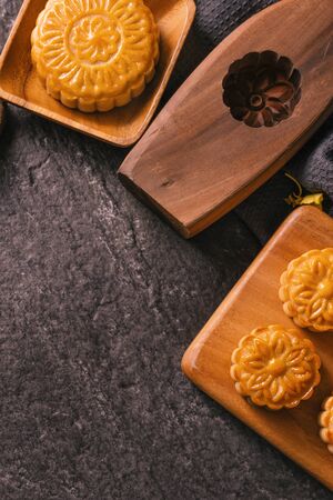 Mid-Autumn Festival traditional food concept - Beautiful Moon cake on black slate table with tea,...