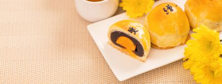 Tasty baked egg yolk pastry mooncake for Mid-Autumn Festival on bright wooden table background....