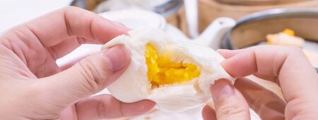 Delicious dim sum, famous cantonese food in asia, fresh and hot salted creamy custard buns in bamboo steamer in hong kong yumcha restaurant, close upの写真素材