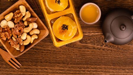 Mooncakes with tea on dark wooden table, holiday concept of Mid-Autumn festival traditional food layout, top view, flat lay, copy space.の写真素材
