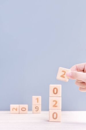 Abstract 2020 & 2019 New year countdown design concept - woman holding wood blocks cubes on wooden...