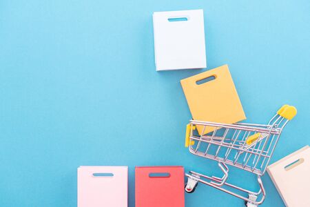 Abstract design element, annual sale, shopping season concept, mini yellow cart with colorful paper...