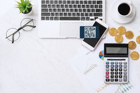 Online payment with QR code concept, virtual credit card, smart phone on office laptop desk on clean marble table background, top view, flat layの写真素材