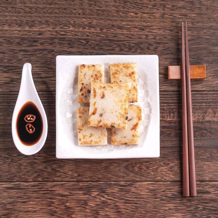 Delicious turnip cake, Chinese traditional radish cake in restaurant with soy sauce for new year's dishes, close up, copy space, top view, flat lay.の写真素材