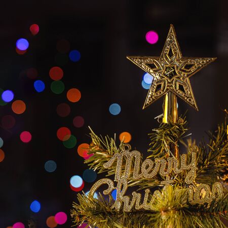 Beautiful Christmas decor concept, bauble hanging on the Christmas tree with sparkling light spot, blurry dark black background, macro detail, close up.の写真素材