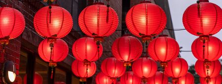 Beautiful round red lantern hanging on old traditional street, concept of Chinese lunar new year festival, close up. The undering word means blessing.の写真素材
