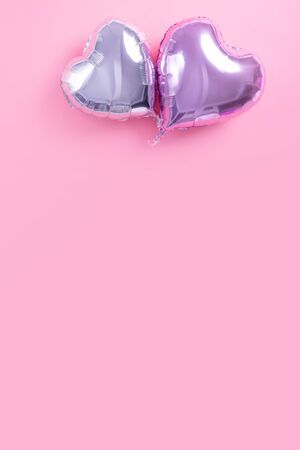 Valentine's Day romantic design concept - Beautiful real heart shape foil balloon isolated on pale pink background, top view, flat lay, overhead above photography.の写真素材
