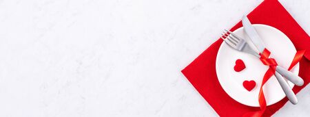 Valentine's Day, Mother's Day, holiday dating meal, banquet design concept - White plate and red ribbon on marble background, top view, flat lay.の写真素材