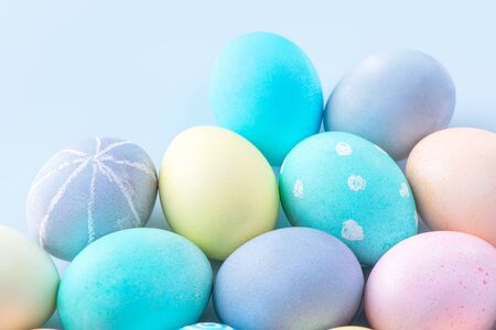 Colorful Easter eggs dyed by colored water isolated on a pale blue background, design concept of...