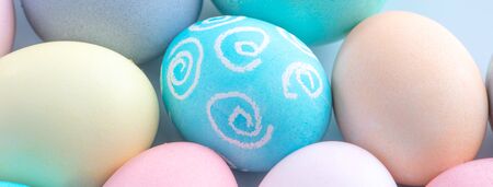 Colorful Easter eggs dyed by colored water isolated on a pale blue background, design concept of...